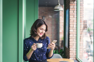 Beautiful cute asian young businesswoman in the cafe, using mobi